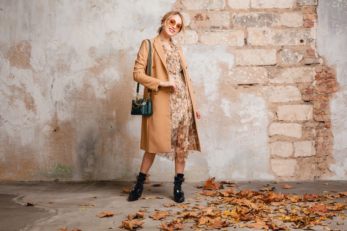 Home Attractive Stylish Blonde Woman Beige Coat Walking Street Against Vintage Wall 1